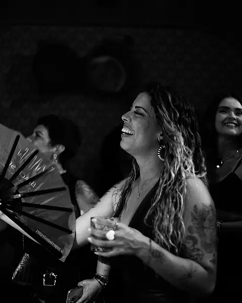 Convidada rindo de leque na mão na pista do Black Music Live