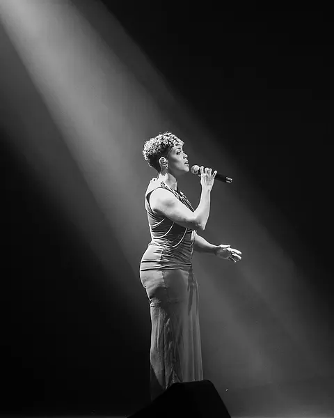 Cantora da Black SP sozinha no facho de luz do palco