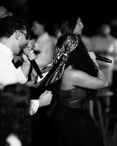 Cantor e cantora da Black SP cantando juntos no meio da pista
